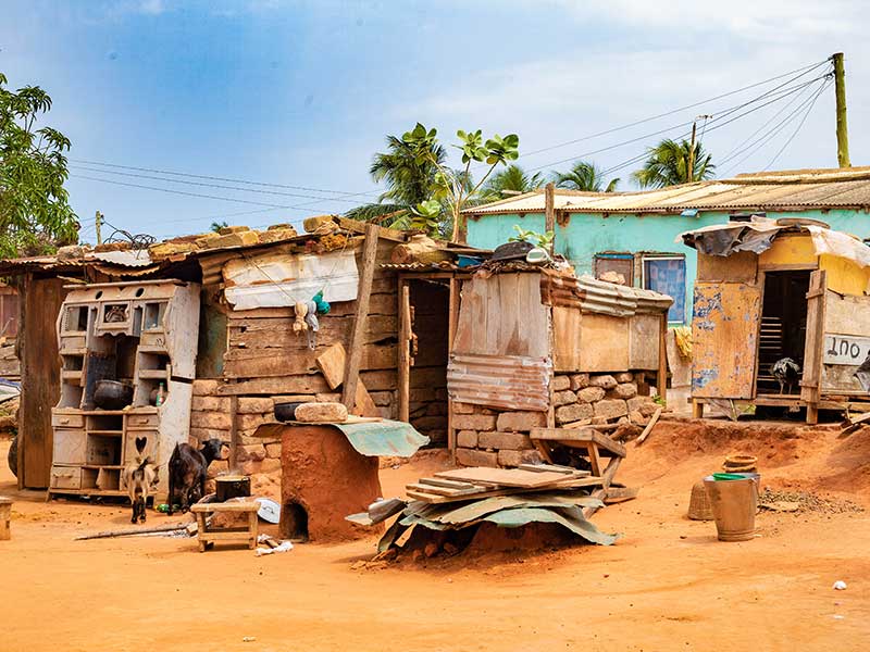 A shack made out of a metal rood and loosely laid bricks.