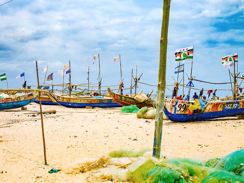 Colorful boats sitting on an ocean beach.