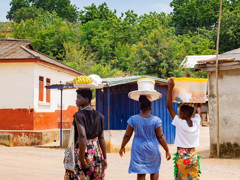 Woman carrying baskets of food on their heads.